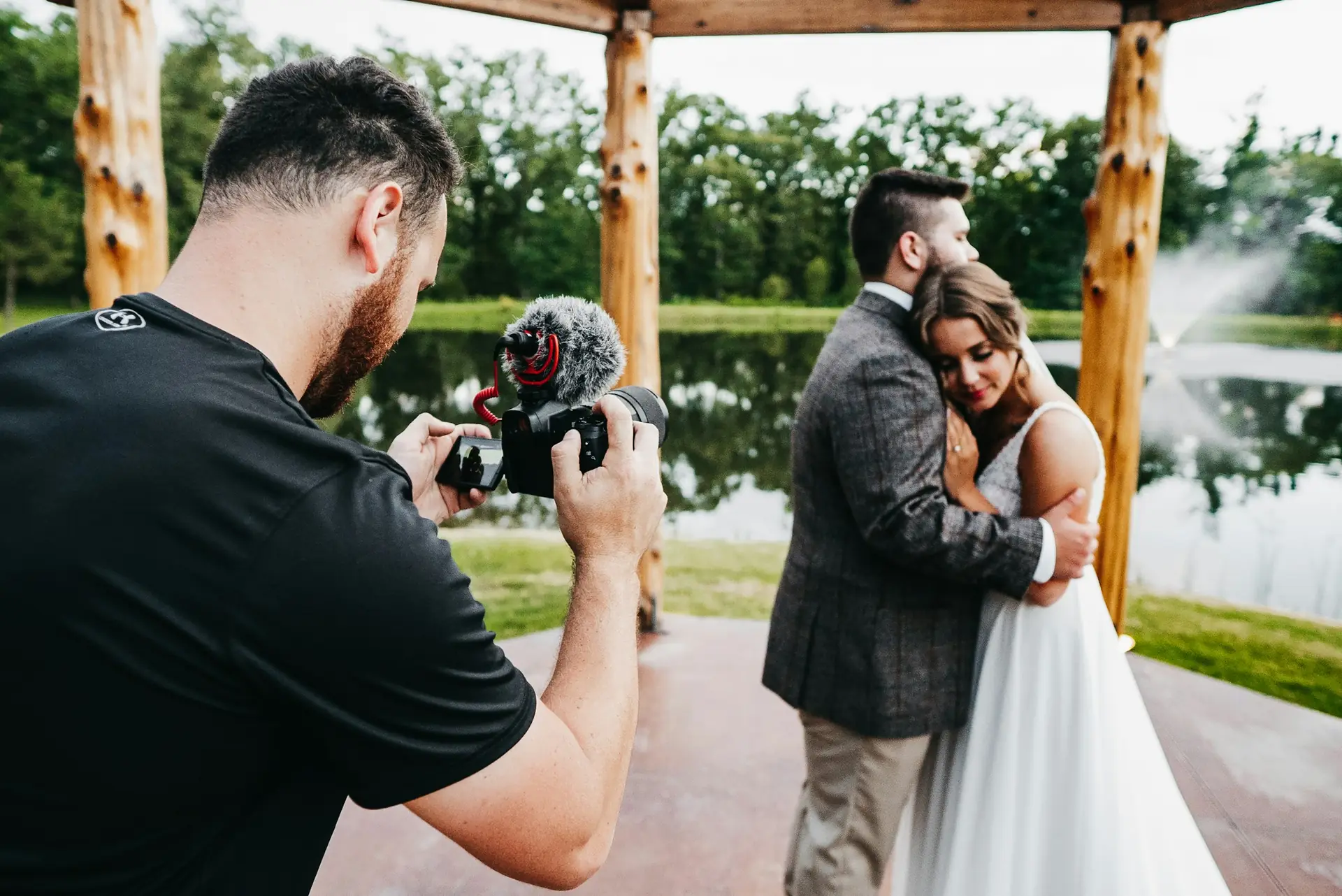 Fotograf de nuntă la lucru, fotografiind mirii îmbrățișați